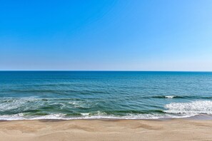 En strand med kristallklart blått vatten och en sandstrand.