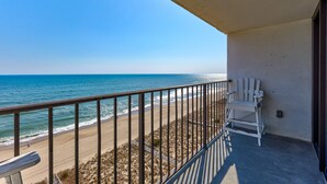Ein Balkon mit Blick auf Strand und Meer.