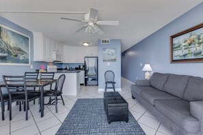 Ett kompakt bostadsutrymme med ett litet kök, matplats och sittgrupp.
