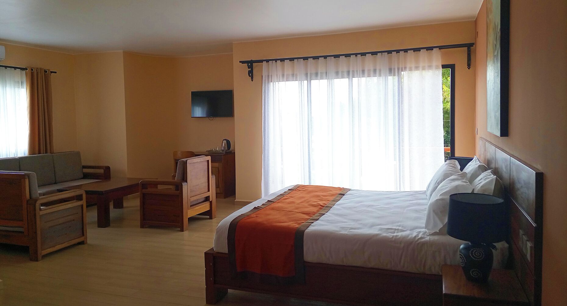 A hotel room with a bed, a TV, a desk, and a chair.