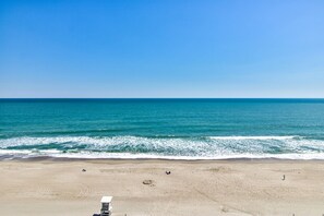 Ein Strand mit einem Rettungsturm, feinem Sand und dem Ozean.