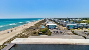 A coastal hotel with a beach view, a parking lot, and a boardwalk. - Oceanfront 2-Bedroom Condo at Carolina Beach 1014 (Carolina Beach)