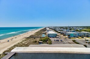 Ein Hotel an der Küste mit Blick auf den Strand, einem Parkplatz und einer Promenade.