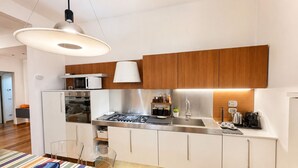 Une cuisine moderne avec des armoires blanches, une cuisinière en acier inoxydable et un four à micro-ondes.