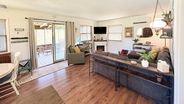 A modern living room with a fireplace, a television, and a dining area with a table and chairs.