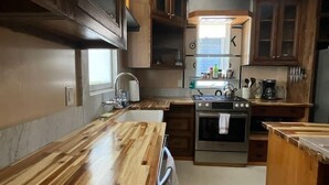A kitchen with wooden cabinets, a stainless steel stove, and a window. - Beautifully Chic, Spacious, WiFi, Near Pullman Yds (Atlanta)