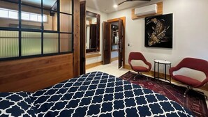 A room with a bed, a ceiling fan, a painting, and a small table. - Beautifully Chic, Spacious, WiFi, Near Pullman Yds (Atlanta)