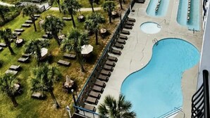 Un complexe hôtelier doté d’une piscine, de chaises longues et offrant une vue sur la plage.