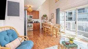 Un appartement moderne comprenant un coin repas, une cuisine et un balcon avec des garde-corps.
