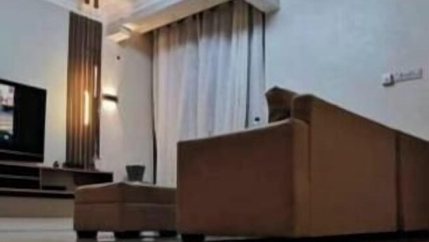 Eine Hotelhalle mit Empfangstresen, Deckenventilator und einer großen Leuchte.