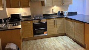 Una cocina moderna con armarios de madera, horno empotrado y microondas.