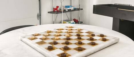 A checkered board with pieces on a marble table.
