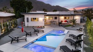 A modern outdoor pool area with lounge chairs, a hot tub, and a patio with a mountain backdrop. - Sunview Escape, a Freshly Remodeled Retreat! (Palm Springs)
