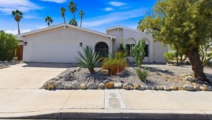 A two-story house with a garage, palm trees, and a desert garden with rocks and cacti. - Welcome to Casa Cielo Vista, a Bright South Palm Springs Retreat! (Palm Springs)