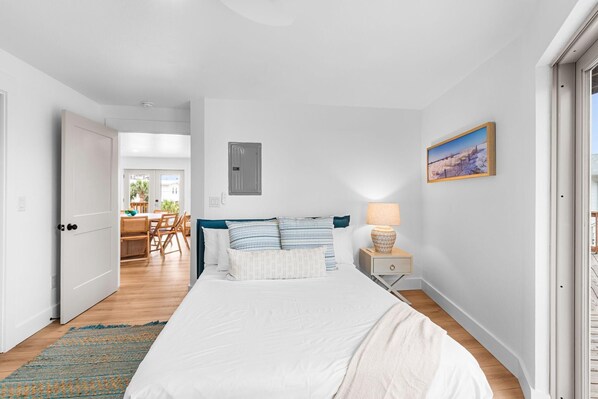 Une chambre à coucher avec un lit, une table de chevet, une lampe et un tableau au mur.