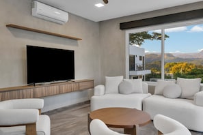 Una sala de estar moderna con televisor de pantalla plana, un sofá y una mesa de centro.