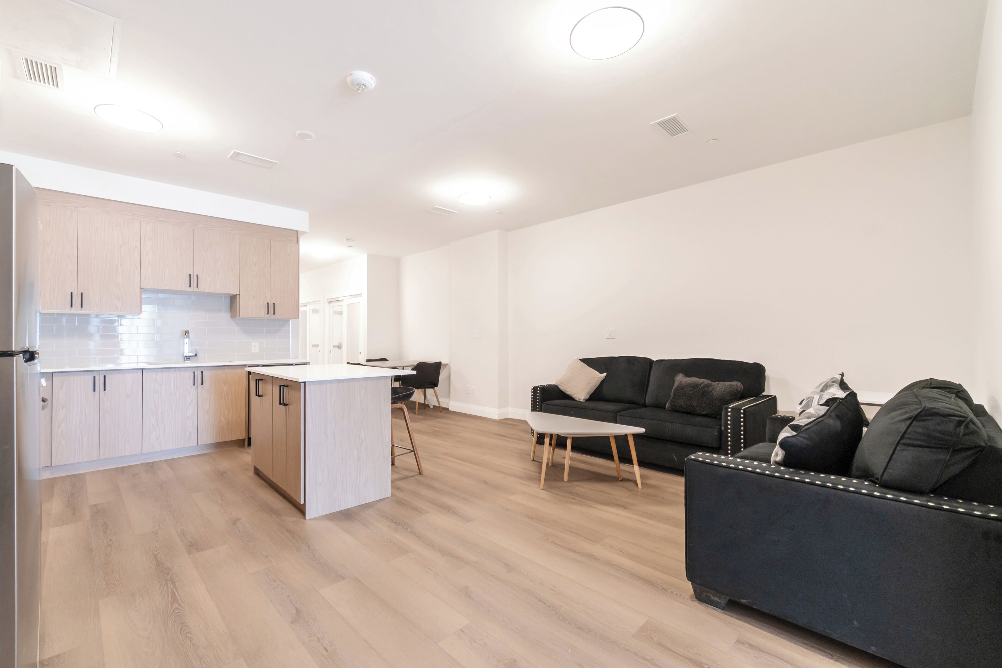 A modern apartment with a kitchen, dining area, and living room.
