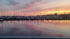 A marina with boats docked, calm water, and a wooden dock. - Charming villa by the sea - sandy beach and sea view in Gislövs Location (Trell)