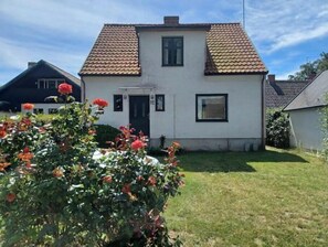 A two-story house with a tiled roof, a front door, and a small window. - Charming villa by the sea - sandy beach and sea view in Gislövs Location (Trell)