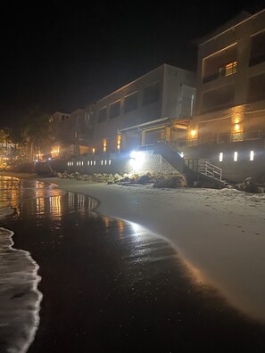 A nighttime beach scene with a building in the background. - Spectacular 2BDRM beachfront Cabarete condo. Steps to nightlife & vibrant Comm, (Cabarete)