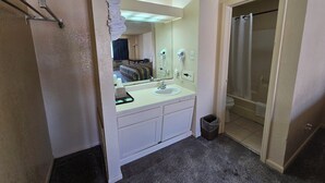 Un baño pequeño con lavabo, espejo y ducha.