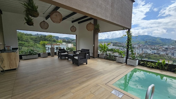 A covered outdoor area with a pool, seating, and potted plants. - Naki Apartamento Santa Rosa de Cabal (Santa Rosa de Cabal)