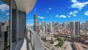 Un immeuble de grande hauteur offrant une vue sur le paysage urbain, notamment un gratte-ciel remarquable surmonté d'une grue.