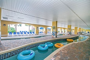 Un espace piscine intérieure avec des chaises longues et des bouées gonflables.
