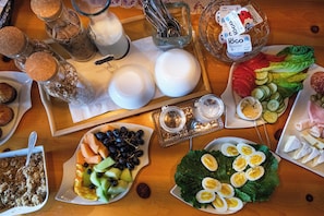 A table with various food items, including fruits, vegetables, and cheeses. - Edelweiss Inn Nova Scotia (Middleton)