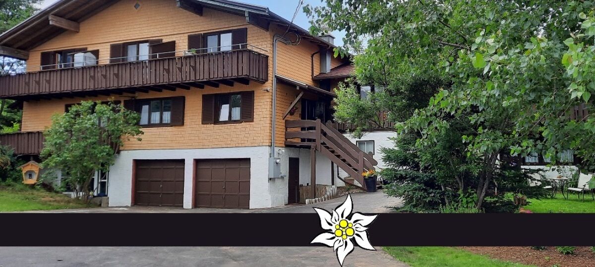 A two-story building with a balcony, a garage, and a staircase leading to the upper floor.