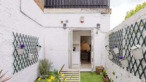 Un edificio de ladrillo blanco con una puerta que da a un espacio interior.