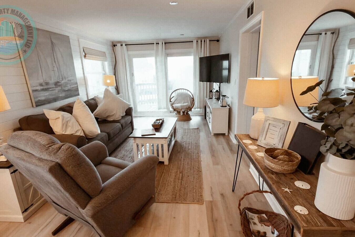 Una sala moderna con un sofá, un sillón, una mesa de centro y un televisor.