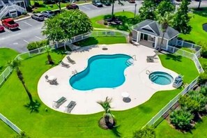 A swimming pool with lounge chairs, a hot tub, and a fenced area with a small house. - Golfers Dream True Blue Golf Resort Pawleys Island (Pawleys Island)