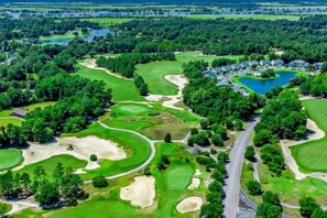A golf course with sand bunkers, water hazards, and a road. - Golfers Dream True Blue Golf Resort Pawleys Island (Pawleys Island)