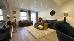Ein modernes Wohnzimmer mit einem Klavier, Sofas, einem Couchtisch und einem Kamin.