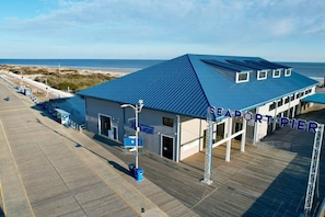 A waterfront police station with a blue roof, a pier, and a beach in the background.