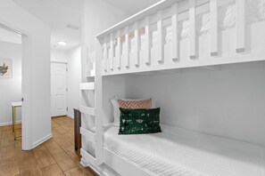 A bunk bed with a ladder, a bedside table, and a pillow with a geometric pattern. - Renovated 1-bedroom condo in lovely Orange Beach (Orange Beach)