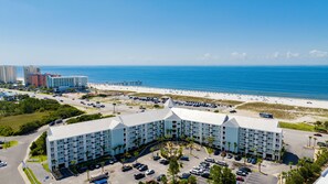 A hotel with a parking lot, a beach, and a view of the ocean. - Renovated 1-bedroom condo in lovely Orange Beach (Orange Beach)