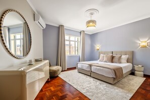 Ein Schlafzimmer mit Bett, Nachttischen, einem Spiegel und einem Fenster.
