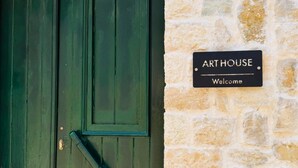 A green wooden door with a 'Welcome' sign on a stone wall. - Art House Seaview & Jacuzzi Spartylas Sleeps 4 (Corfu)