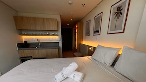 A hotel room with a bed, a small kitchenette, a bathroom, and a hallway. - Setai Aquamares - Miramar Hospedagens (João Pessoa)