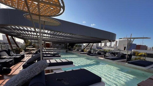 A rooftop pool area with lounge chairs and a covered seating area. - Setai Aquamares - Miramar Hospedagens (João Pessoa)