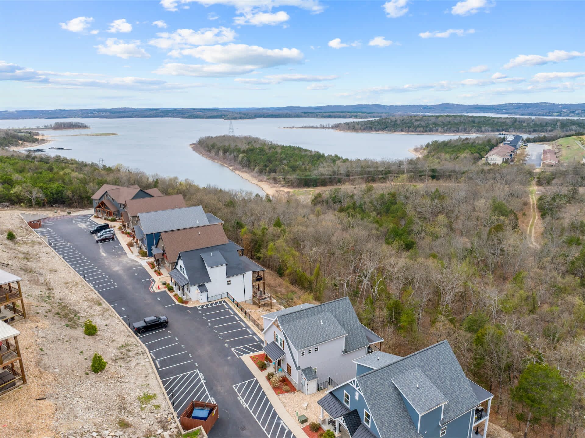 A residential area with houses, a parking lot, and a lake in the background.