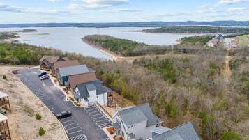 A residential area with houses, a parking lot, and a lake in the background.
