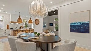 Un comedor moderno con una mesa redonda, sillas e iluminación colgante.