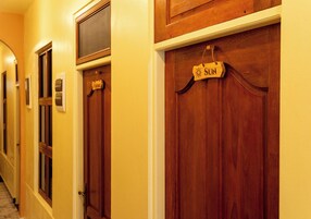 Un pasillo con puertas de madera, cada una con un cartel que indica su destino.