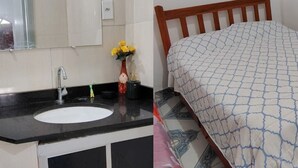 A bathroom with a sink, mirror, and a vase with yellow flowers. - Guesthouse facing Silves, 5 minutes from the bus terminal, with river access. (Silves)