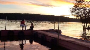 A wooden dock extending into calm water with a sunset in the background. - Guesthouse facing Silves, 5 minutes from the bus terminal, with river access. (Silves)
