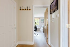 A hallway with a coat rack, a framed picture, and a telephone. - Gorgeous 1BDR Flat in the Heart of Clapham (Greater London)