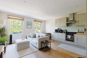 A modern kitchen with grey cabinets, a black countertop, and a built-in oven. - Gorgeous 1BDR Flat in the Heart of Clapham (Greater London)
